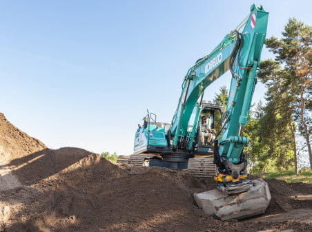 Dette billede illustrere Kobelco gravemaskiner bliver udstyret med Engcon’s tiltrotator og automatisk tiltfunktion