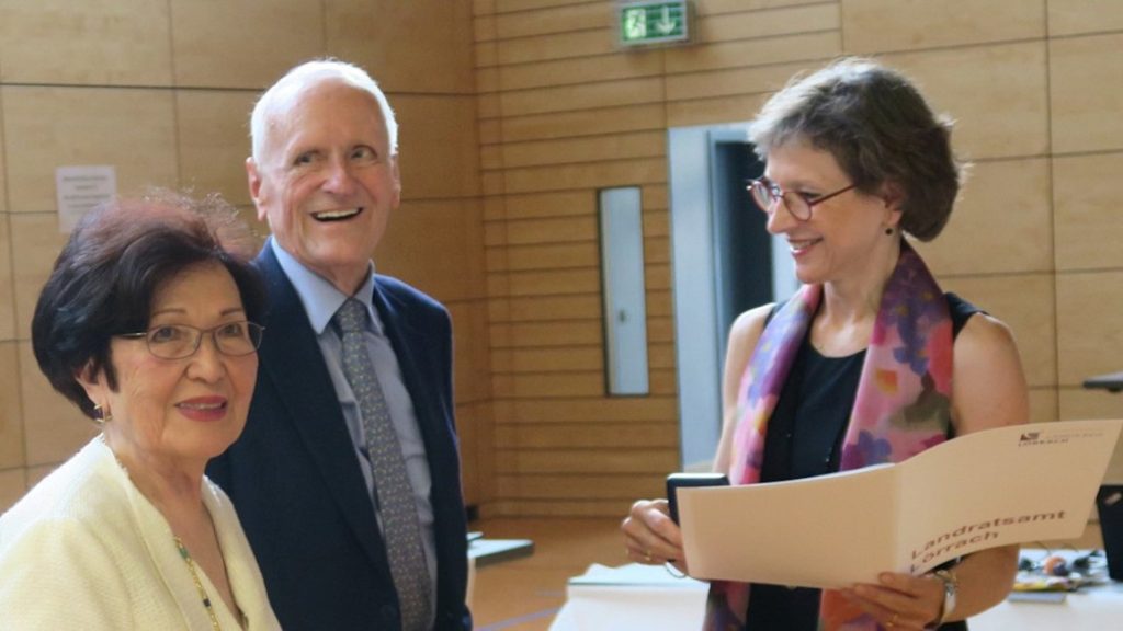 Distriktsadministrator Marion Dammann præsenterer Ayhan og Dr. Karl Busch for Æres Guldmedalje. Kilde: Busch Vacuum Solutions.