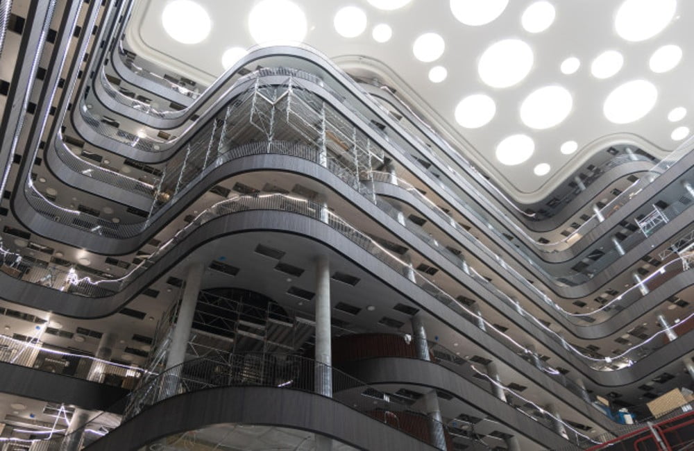 Når man træder ind i foyeren mødes man af et imponerende syn, hvor lamelpanelerne ved hver etage i en bølgende form giver æstetik og varme.