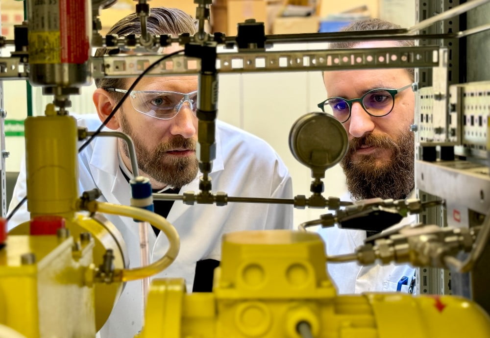 Til udvikling af katalysatoren har Teknologisk Institut benyttet produktionsmetoden Hydro termisk flowsyntese, der anvender vand som solvent under syntesen. Her ses Christian Kallesøe (tv) og Simon Pitscheider (th) foran en af Instituttets flowreaktorer. Teknologisk Institut