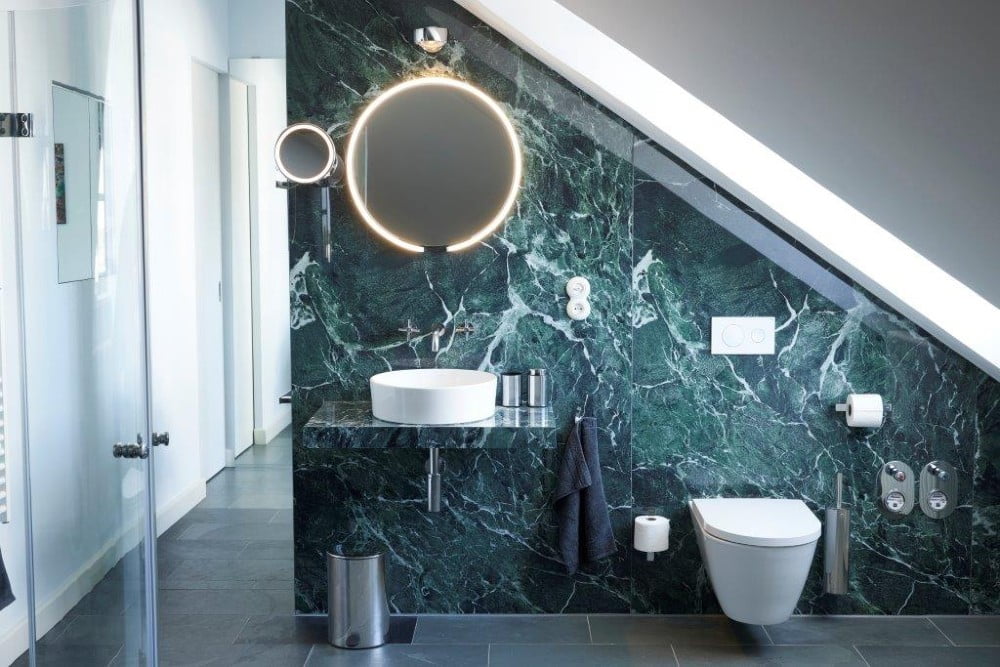 Unidrains ikoniske linjeafløb til to brusenicher samt produkter fra deres eksklusive Reframe-kollektionen fuldender visionen for lejligheden på Rumpenheim Slot.