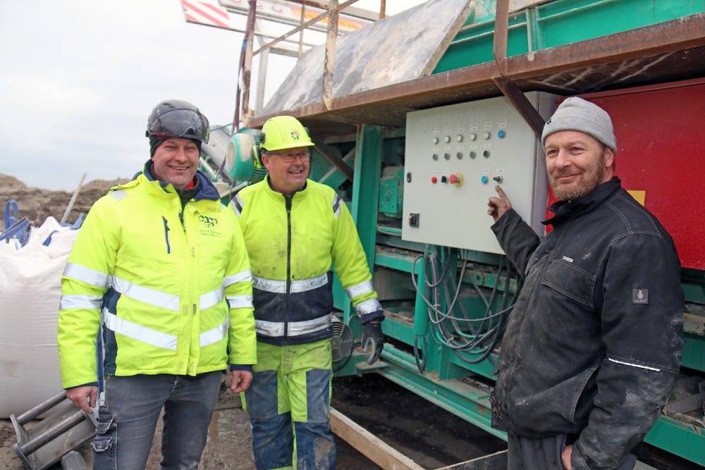 Carsten Johansen (tv) etablerede sammen med Lars Møllegaard Pedersen (i midten) Dansk Anlægsteknik ApS i 2021. De ses her sammen med værkfører Torben Christensen (th) fra virksomheden JRMS, der her bygget anlægget, som danner rammen om den patenterede jordbehandlingsmetode.