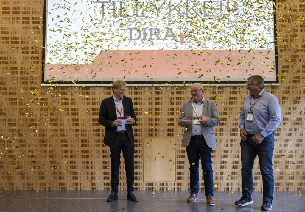 Sådan så det ud, da DIRA Automatiseringsprisen blev uddelt på AUTOMATIK-messen i 2022. Fra venstre ses Jacob Kjeldsen, branchedirektør i Dansk Industri, samt John Sandholm og Per Nielsen fra Palsgaard Spær, der vandt prisen. Foto: MCH/Lars Møller.

 
 