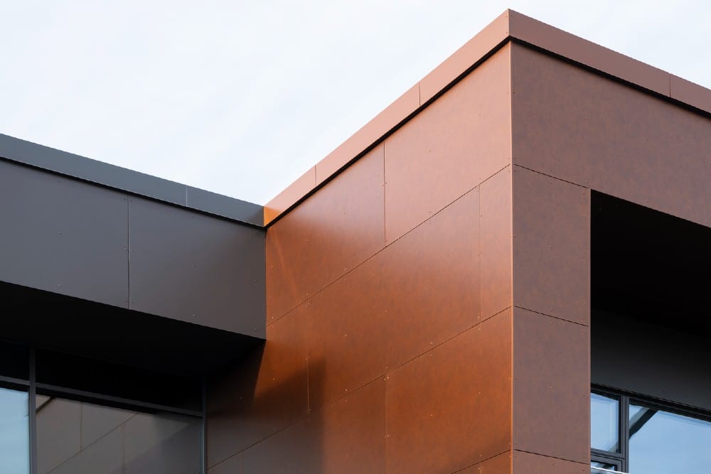 Med en facade i Rockpanel Metals Bronze og en lysere Dark Copper på gårdsiden, tilfører bygningen styrke og signalværdi. Logoet er subtilt integreret i arkitekturen og kan fornemmes fra luften. 